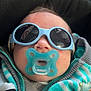 baby, blue, casual, child, closeup, cozy, cute, face, gray, hand, indoors, infant, jacket, pacifier, portrait, relaxed, small, soft, striped_clothing, sunglasses