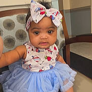 Unique is registered to the contest to win money with this photo: baby, child, infant, portrait, sitting, chair, bow, headband, tutu, dress, blue, colorful, smiling, face, indoors, furniture, fashion, cute, legs, feet