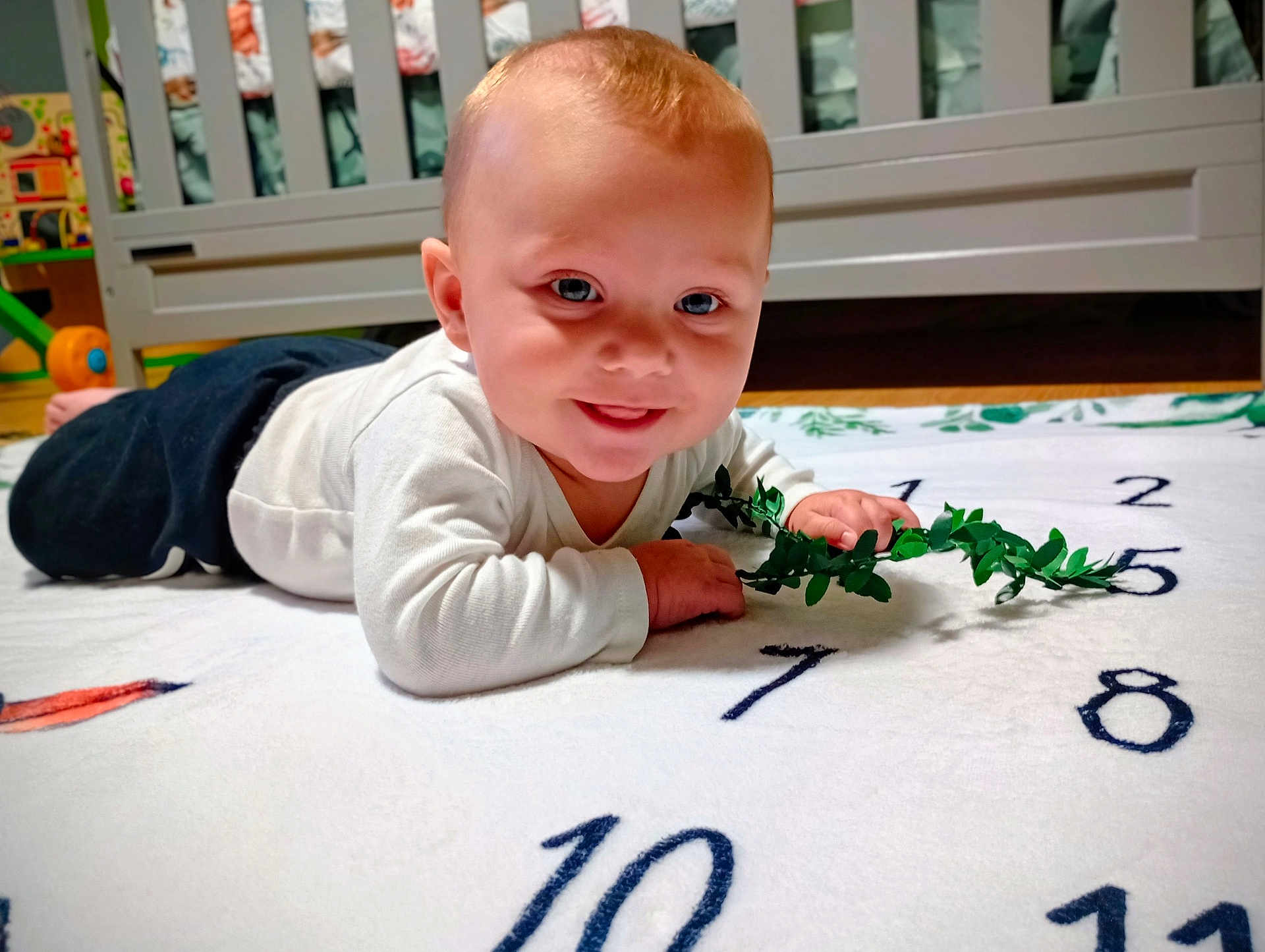 Waylon joined the competition — help win amazing prizes! baby, child, smile, blanket, numbers, greenery, toy, crib, indoor, floor, white, clothing, happy, face, infant, toddler, play, cute, person, home