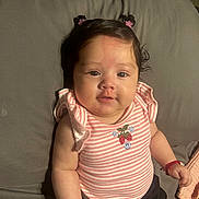 Ailany is registered to the contest to win money with this photo: accessories, baby, bottle, bracelet, child, couch, cute, face, gray_background, hair_buns, indoors, infant, pink_clothing, portrait, sitting, smiling, soft_lighting, strawberry_embroidery, striped_shirt, young_child