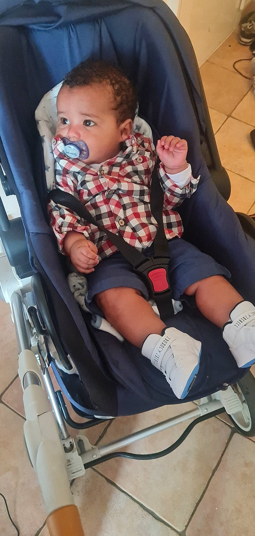 Liyam a rejoint le concours — aidez-le/la à gagner de superbes lots ! baby, baby_carriage, baby_products, baby_toddler_clothing, black, chair, child, comfort, foot, head, human_leg, knee, lap, leg, person, shorts, sitting, sock, thigh, toddler