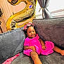 Malauni is registered to the contest to win money with this photo: toddler, child, birthday, balloon, number_two, pink_dress, smile, couch, gray_cushion, curtains, window, indoors, celebration, happy, headband, person, furniture, relaxing, home, natural_light