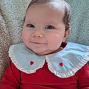 Thalie participe au concours pour gagner de l'argent avec cette photo : baby, infant, smile, red_clothing, blue_collar, heart_pattern, knitted_blanket, cozy, cute, portrait, child, indoors, happy, face, person, head, sitting, young_child, toddler, warm
