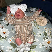 Oaklynn joined the competition — help win amazing prizes! baby, infant, newborn, onesie, headband, bow, cushion, floral_pattern, plush, milestone, wooden_plaque, sleeping, person, adult_arm, striped_clothing, white_socks, indoor, closeup, comfort, resting