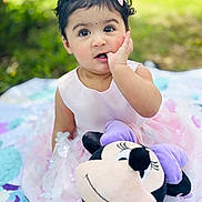 Naomi is registered to the contest to win money with this photo: baby, child, dress, pink, plush_toy, minnie_mouse, blanket, outdoor, grass, cute, portrait, sitting, finger_in_mouth, hair_clip, person, toy, childhood, smile, young, playtime
