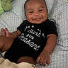 Kayceon is registered to the contest to win money with this photo: baby, smiling, onesie, black_clothing, blanket, plush_toy, infant, happy, portrait, cute, child, soft_texture, lying_down, indoors, cozy, baby_hand, baby_face, infant_clothing, expression, young_child