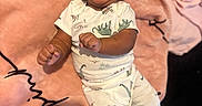 Kayceon is registered to the contest to win money with this photo: baby, smiling, laughing, infant, blanket, pink, dinosaur_print, clothing, striped_socks, cute, happy, lying_down, cozy, child, person, indoors, soft_texture, joy, expression, casual
