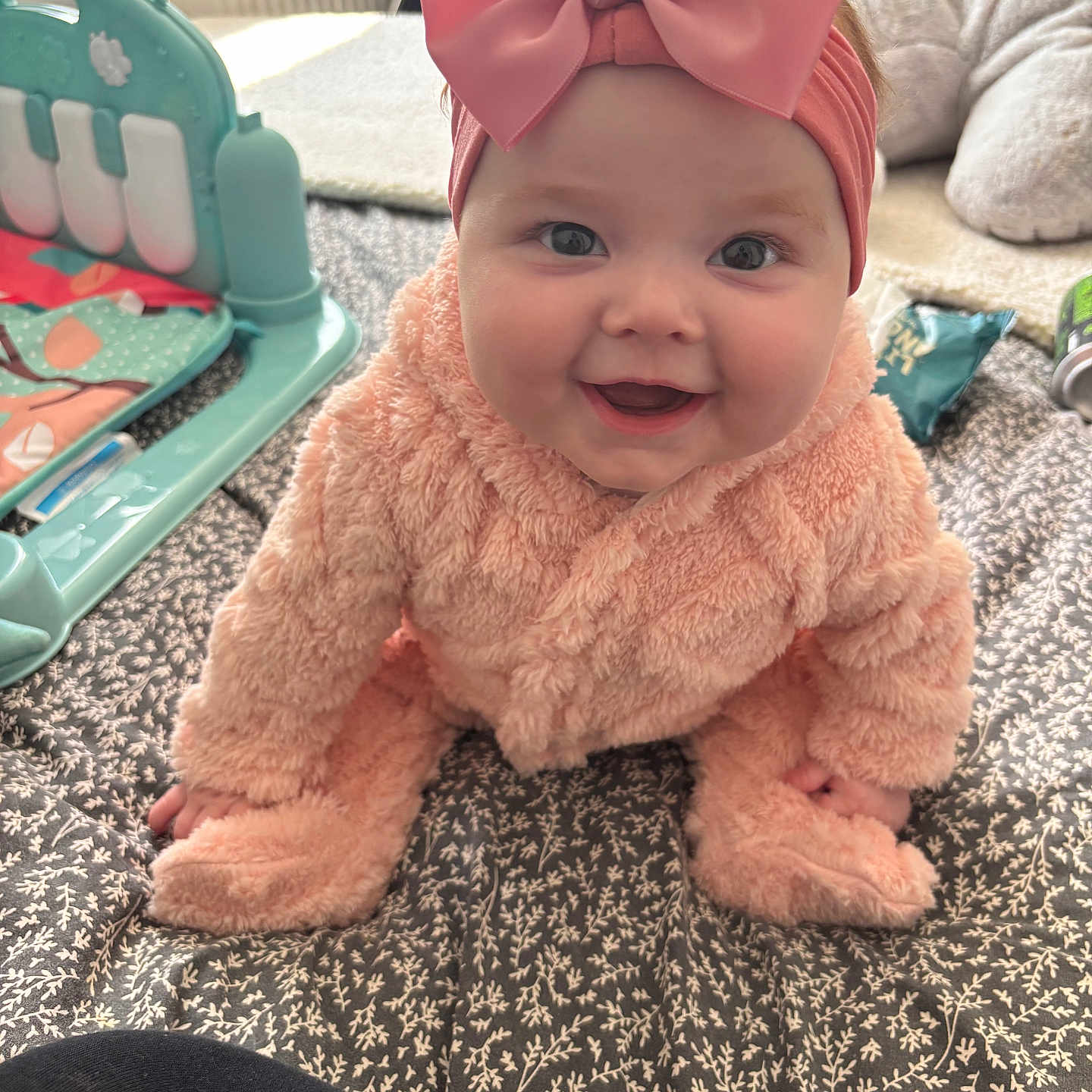 Rein-Rose joined the competition — help win amazing prizes! baby, blanket, child, cozy, crawling, cute, floor, fluffy_outfit, happy, headband, home, indoor, infant, patterned, person, pink_bow, playtime, smiling, soft_texture, toy