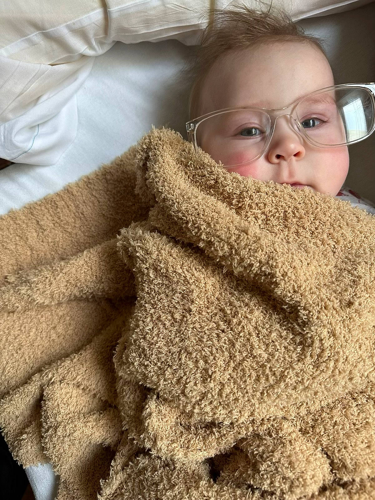 Freyja is registered to the contest to win money with this photo: carpet, child, comfort, eyelash, eyewear, flooring, fur, gesture, grass, knitting, linens, pattern, person, shawl, sleeve, textile, toddler, vision_care, wool, woolen