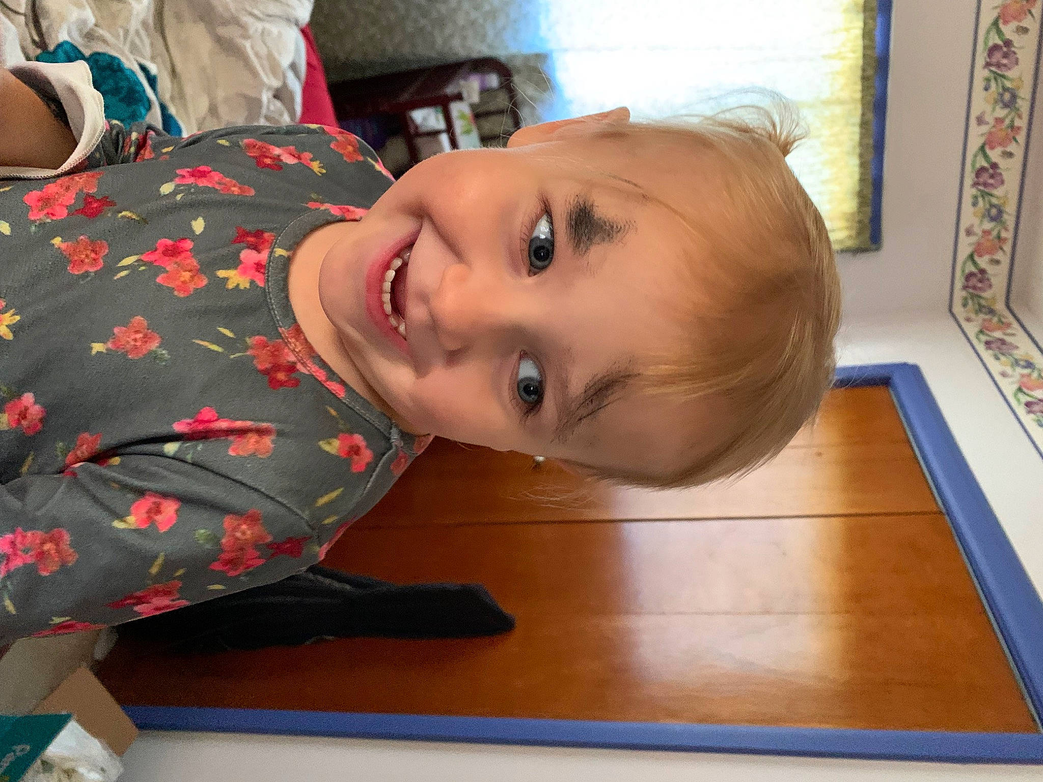 Athena joined the competition — help win amazing prizes! baby_toddler_clothing, cheek, child, flooring, fun, happy, hardwood, joy, nose, pattern, person, picture_frame, room, sitting, skin, sleeve, smile, toddler, varnish, wood