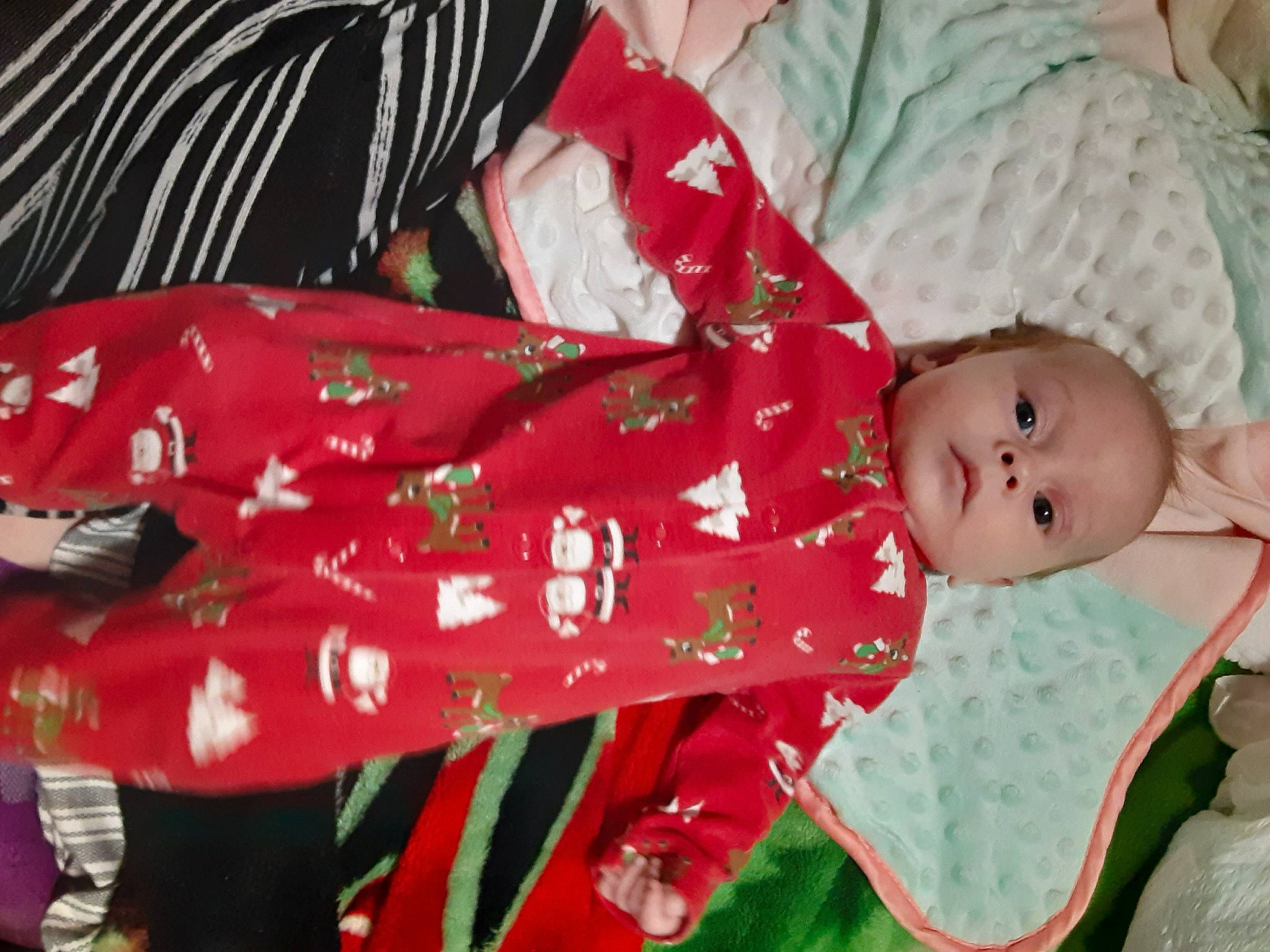 Azariah is registered to the contest to win money with this photo: baby, baby_products, baby_toddler_clothing, carmine, child, christmas, christmas_eve, comfort, event, facial_expression, grass, happy, holiday, lap, linens, pattern, person, sitting, sleeve, textile