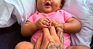 Zsamiya joined the competition — help win amazing prizes! baby, infant, pink_clothing, hand, tattoo, pillow, couch, skin, smile, happy, child, cute, indoor, person, holding_hands, relax, comfort, portrait, young_child, human