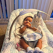 Zsamiya is registered to the contest to win money with this photo: baby, infant, baby_seat, toy, bunny_toy, pacifier, socks, carpet, vertical_blinds, patterned_fabric, indoor, child, cute, hands, looking_up, white_clothing, soft_toy, home, floor, resting