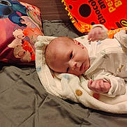 Hayden is registered to the contest to win money with this photo: baby, blanket, bed, pillow, stitch, cartoon, infant, child, cozy, sleepwear, cute, soft, warm, indoor, portrait, newborn, lying_down, fabric, colorful, resting