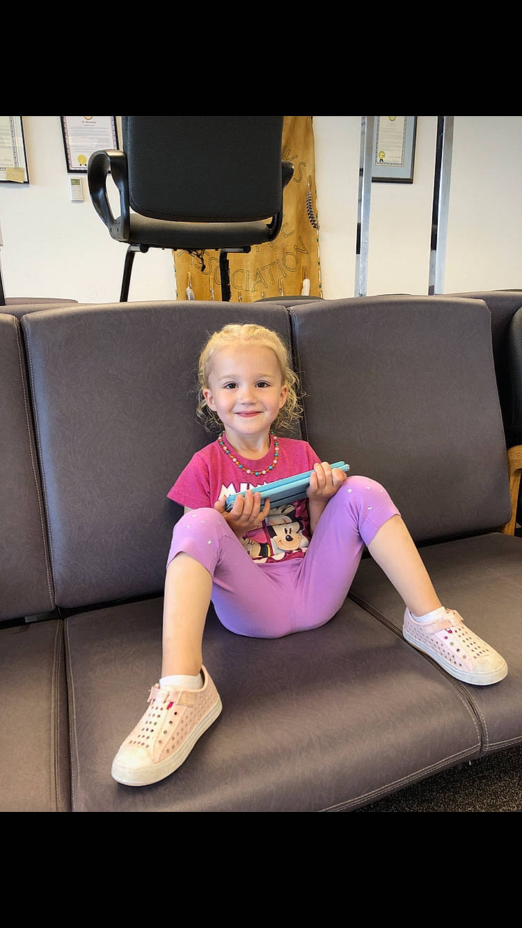 Sanza is registered to the contest to win money with this photo: arm, child, couch, flooring, fun, furniture, joint, joy, knee, leg, person, shoe, shoulder, sitting, sportswear, toddler