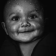 Zakarïa participe au concours pour gagner de l'argent avec cette photo : adorable, baby, black_and_white, child, chubby_cheeks, close_up, cute, dark_background, expression, eyes, face, head, infant, monochrome, portrait, skin_texture, smiling, water_droplets, wet_face, young_child