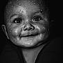 adorable, baby, black_and_white, child, chubby_cheeks, close_up, cute, dark_background, expression, eyes, face, head, infant, monochrome, portrait, skin_texture, smiling, water_droplets, wet_face, young_child