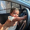 baby, car, casual, child, clothing, cute, expression, face, hand, holding, infant, interior, person, portrait, seat, skin, steering_wheel, sunlight, window, young