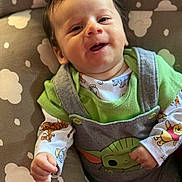 Antony Romeo joined the competition — help win amazing prizes! baby, smiling, infant, overalls, cartoon_character, clothing, cushion, cloud_pattern, happy, face, person, cute, child, indoors, portrait, young, hand, green_shirt, playful, cozy