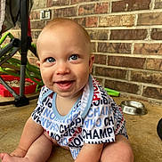 Zymani joined the competition — help win amazing prizes! baby, child, smiling, sitting, onesie, blue_eyes, brick_wall, floor, stroller, metal_bowl, happy, cute, indoor, portrait, person, clothing, infant, face, baby_girl, baby_boy