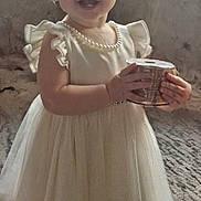 Lexi joined the competition — help win amazing prizes! barefoot, carpet, child, cute, dress, floor, girl, hair_tied, happy, holding_object, home, indoor, pearl_necklace, person, portrait, ribbon, short_hair, smiling, standing, toddler