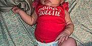 Laila joined the competition — help win amazing prizes! baby, sleeping, infant, red_shirt, diaper, pacifier, bed, blanket, pattern, skin, hand, foot, face, person, resting, cute, toddler, child, indoors, cozy