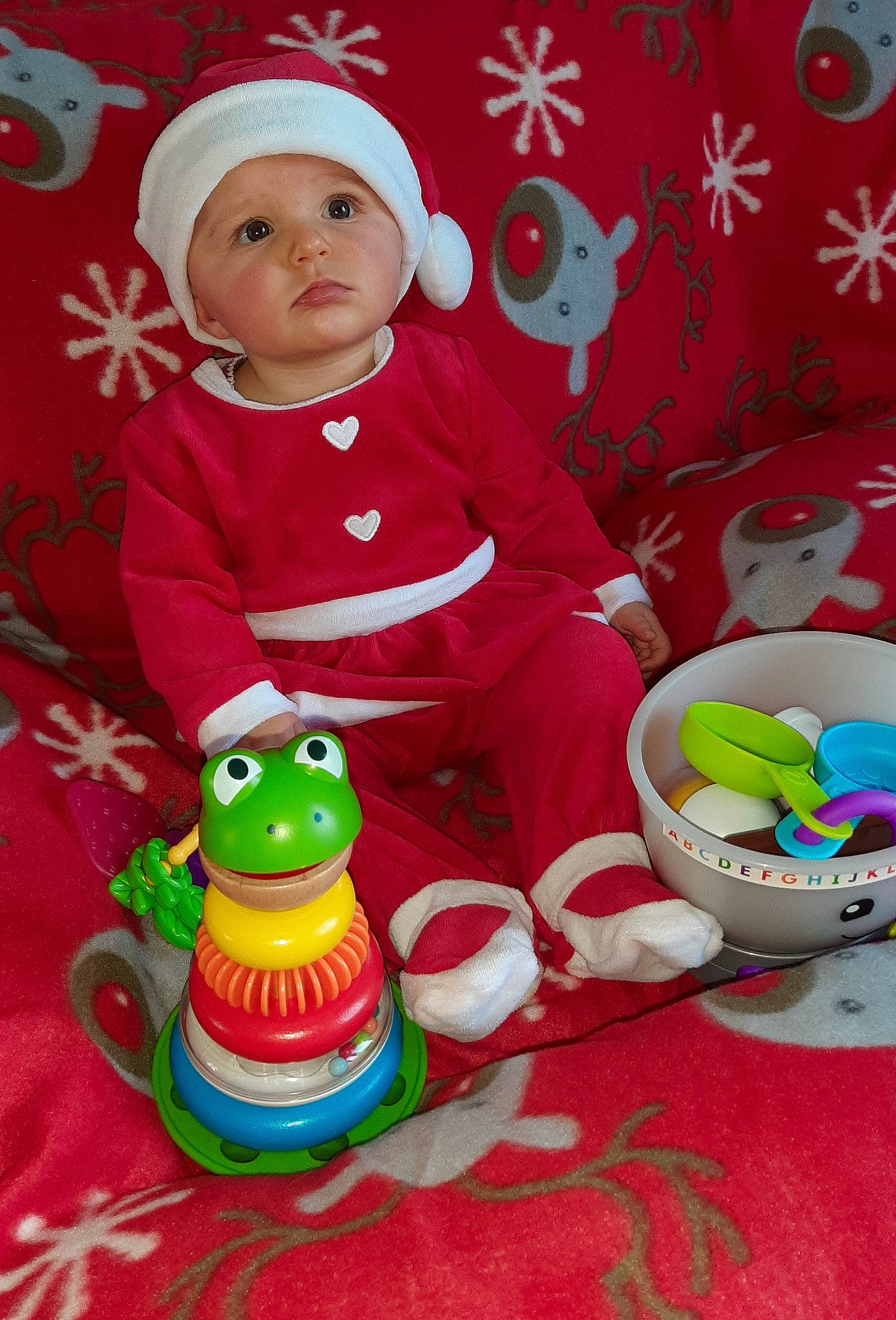 Harmonie participe au concours pour gagner de l'argent avec cette photo : baby, baby_products, baby_toddler_clothing, baby_toys, cap, child, event, fictional_character, fun, happy, headwear, holiday, organ, person, pink, product, red, sitting, sleeve, toddler