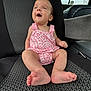 Oak is registered to the contest to win money with this photo: baby, infant, child, pink_clothing, romper, car_seat, patterned_seat, barefoot, happy, smiling, hair_tuft, sitting, indoors, vehicle_interior, seat, person, cute, small_feet, portrait, joyful