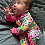 Oak joined the competition — help win amazing prizes! baby, infant, child, onesie, floral_pattern, pink, hand, face, expression, curious, lying_down, bed, quilt, soft, cute, portrait, young_child, sleepwear, cozy, indoor