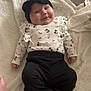 baby, infant, smiling, headband, black_pants, floral_top, blanket, cute, cozy, indoor, child, face, clothing, person, foot, hand, lying_down, soft_texture, happy, adorable