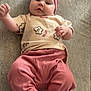 baby, infant, headband, pink_clothing, pants, tshirt, flower_pattern, lying_down, barefoot, cute, chubby, indoors, soft_texture, skin, face, person, child, young, expression, portrait
