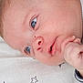 Arthur participe au concours pour gagner de l'argent avec cette photo : baby, infant, face, hand, blue_eyes, skin, newborn, portrait, close_up, lying_down, blanket, star_pattern, cute, soft, child, expression, sleepwear, fingertips, head, cheek