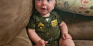 Kayson joined the competition — help win amazing prizes! baby, infant, couch, onesie, camouflage, major_cutie, cute, child, sitting, face, skin, foot, hand, pillow, animal_pattern, indoor, soft, comfortable, expression, curious