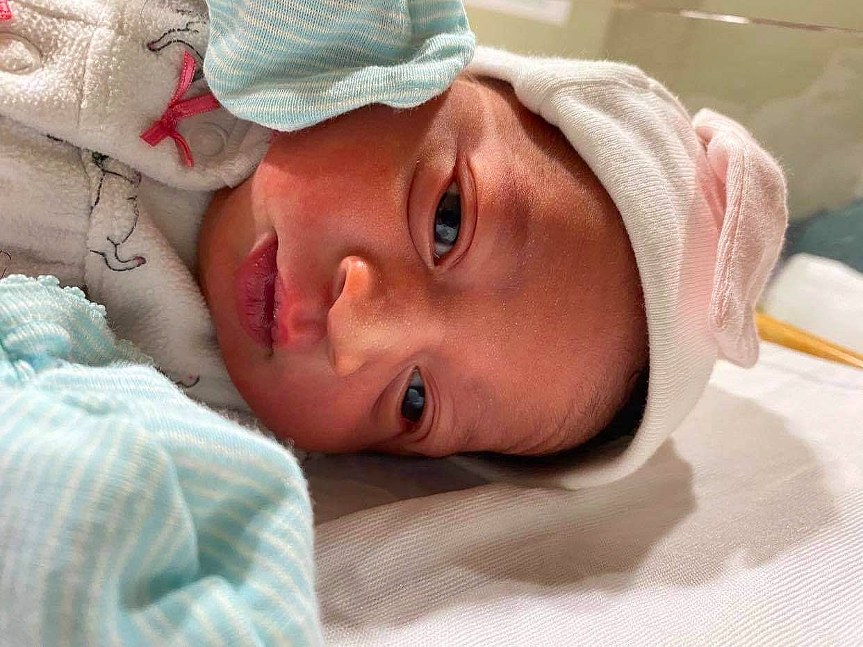 Carmen is registered to the contest to win money with this photo: baby, cap, cheek, child, childbirth, comfort, eyebrow, eyelash, happy, hat, headgear, hospital, linens, lip, mouth, nose, person, skin, smile, toddler