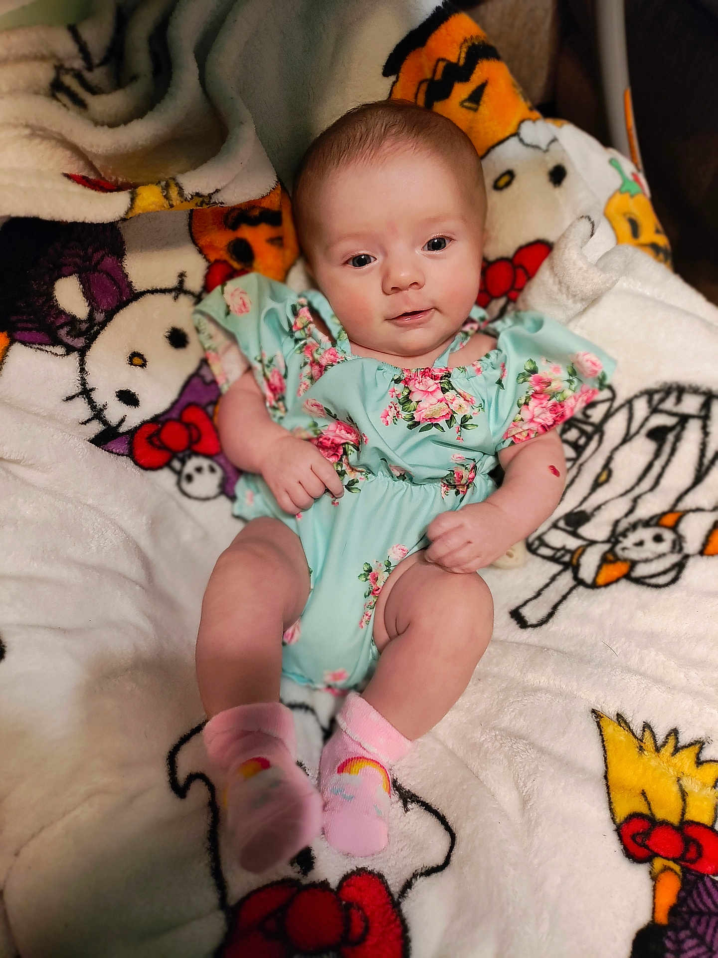 Zanna is registered to the contest to win money with this photo: baby, infant, child, blanket, floral_outfit, pink_socks, cute, smiling, portrait, indoor, soft_texture, comfort, colorful, cartoon_characters, happy, young, face, skin, cute_baby, relaxed