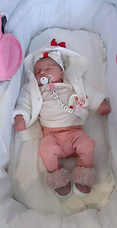 Leyla participe au concours pour gagner de l'argent avec cette photo : baby, baby_products, baby_safety, baby_sleeping, baby_toddler_clothing, bedding, cheek, child, comfort, hat, headgear, human_body, linens, magenta, peach, person, pink, skin, sleeve, toddler
