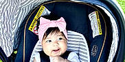 Kassandra joined the competition — help win amazing prizes! baby, car_seat, pink_bow, blanket, smiling, child, outdoor, grass, infant, headband, seatbelt, striped, happy, person, cute, child_seat, toddler, sunny, nature, portrait