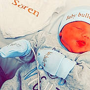 Sören a rejoint le concours — aidez-le/la à gagner de superbes lots ! baby, newborn, sleeping, mittens, hat, blue_clothing, blanket, embroidered_text, infant, cute, soft_texture, cozy, closeup, face, peaceful, resting, bed, cute_baby, child, portrait
