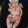 baby, infant, child, headband, bow, pink_outfit, ruffles, socks, baby_seat, black_background, cute, portrait, small_hands, small_feet, clothing, person, young_child, indoor, comfort, seat