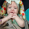 Esmerella is registered to the contest to win money with this photo: baby, child, headband, bow, blanket, cushion, colorful, floral, infant, fingers, mouth, face, portrait, cute, seated, clothing, soft, indoors, closeup, person