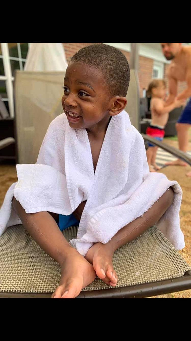 Gary is registered to the contest to win money with this photo: arm, child, hand, individual_sports, japanese_martial_arts, jujutsu, karate, martial_arts, martial_arts_uniform, person, robe, room, sitting, smile