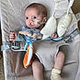 baby, infant, bouncer, soft_toys, socks, medical_tube, indoors, child, cute, seated, fabric, toy, baby_clothes, human, young_child, comfort, expression, looking_away, baby_seat, carpet