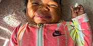 Ilyes is registered to the contest to win money with this photo: baby, smiling, onesie, nike, infant, happy, face, child, clothing, blanket, indoor, cute, cozy, portrait, person, light, shadow, soft, head, babywear