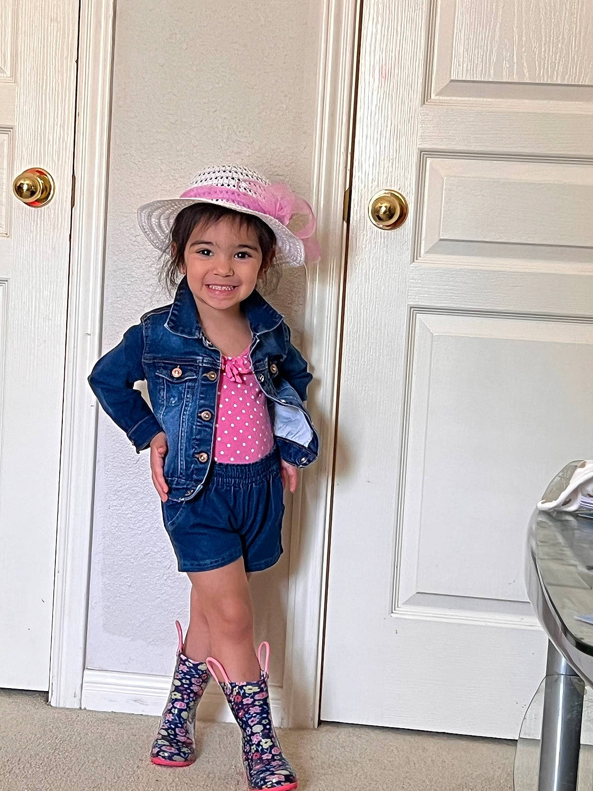 Audrina is registered to the contest to win money with this photo: baby_toddler_clothing, door, face, fashion_design, hat, headgear, joy, knee, magenta, pattern, person, pink, purple, sleeve, smile, standing, street_fashion, sun_hat, textile, toddler