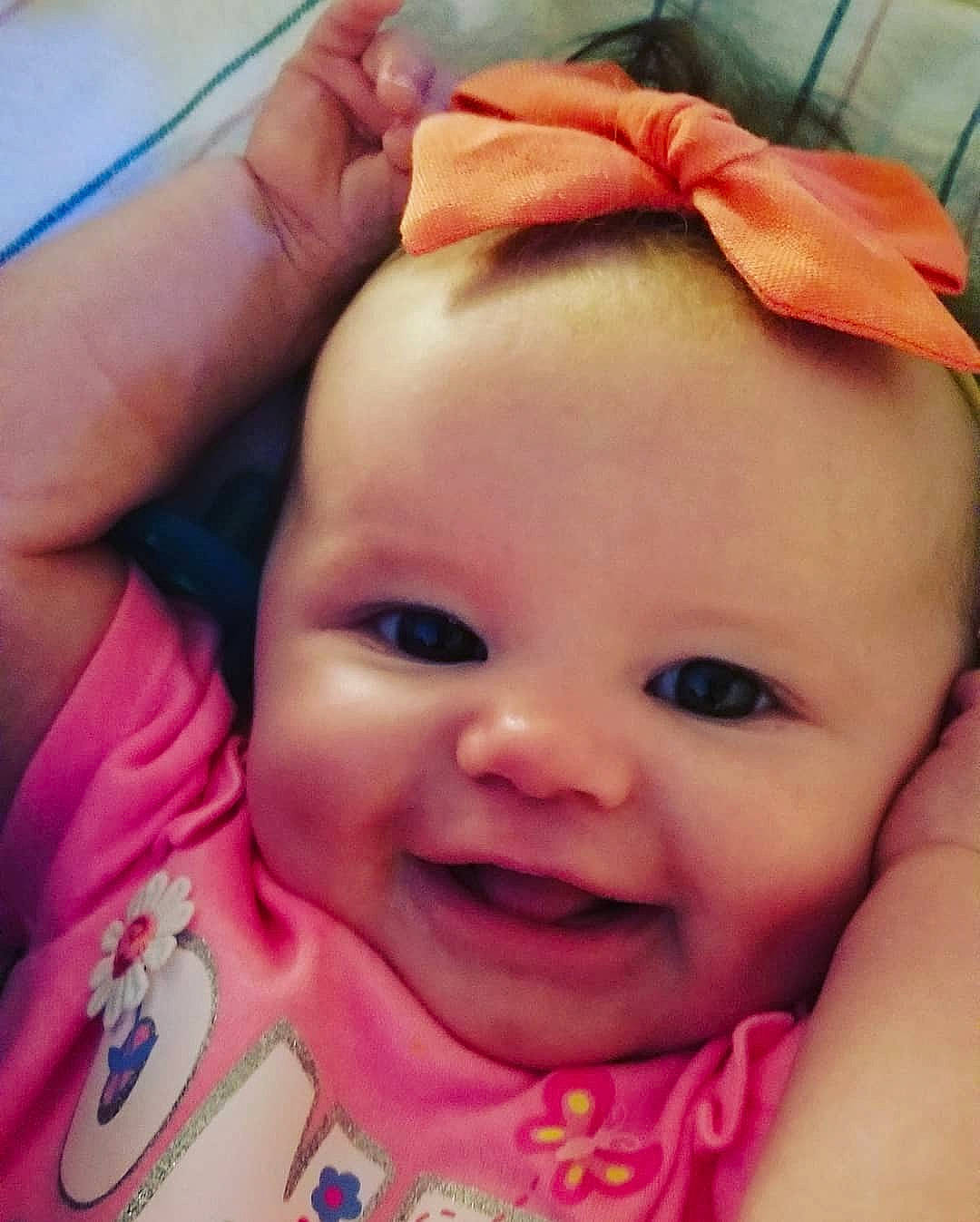 Emily Rose is registered to the contest to win money with this photo: baby, baby_making_funny_faces, cheek, child, chin, close_up, eye, eyebrow, face, facial_expression, forehead, hair_accessory, head, joy, lip, mouth, nose, person, pink, skin
