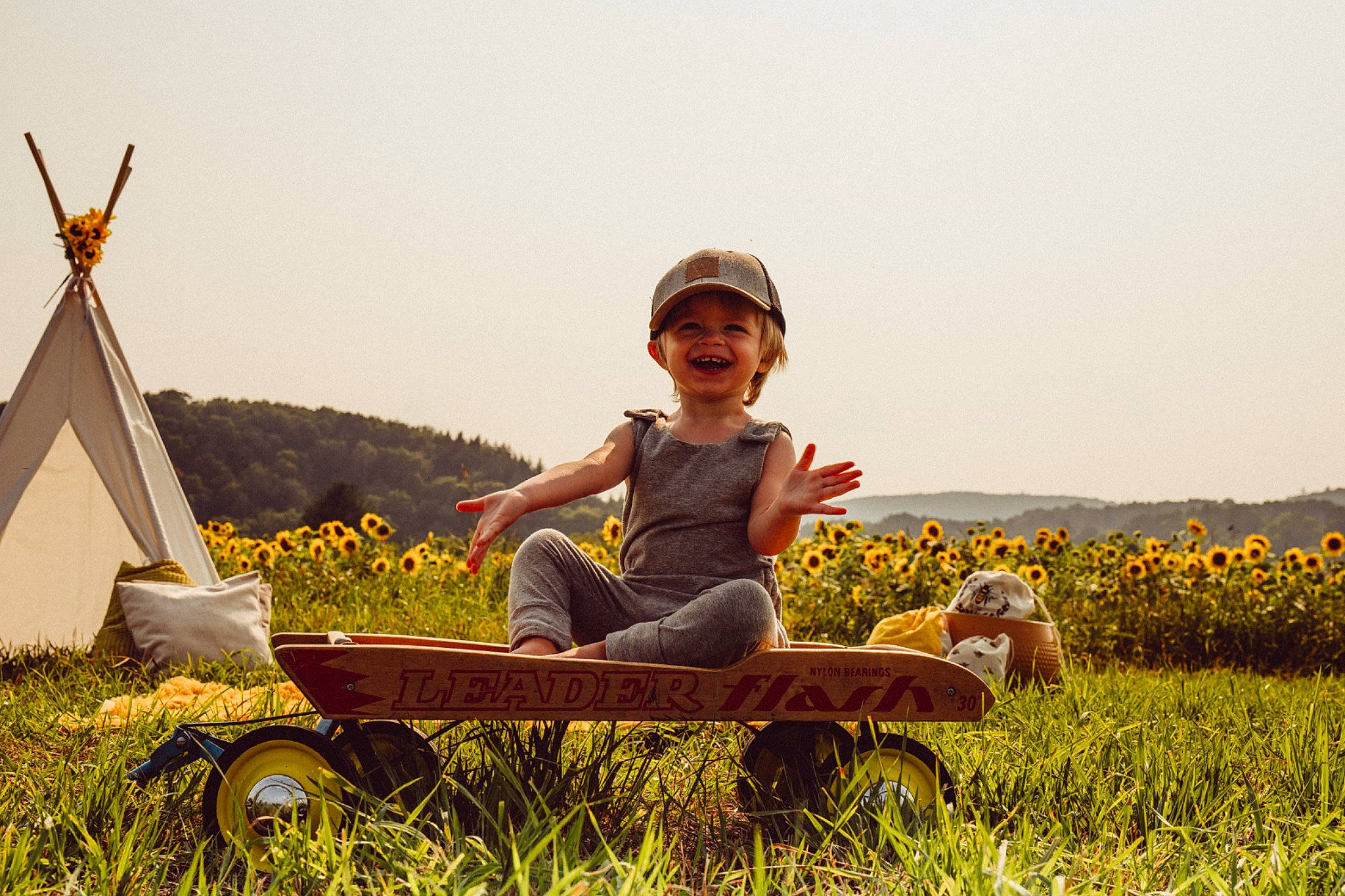 Ludovic participe au concours pour gagner de l'argent avec cette photo : grass, grassland, happy, hat, headwear, joy, landscape, leisure, mammal, people_in_nature, person, plant, sky, smile, summer, sun_hat, sunlight, tire, toddler, travel