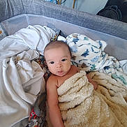 Lucas joined the competition — help win amazing prizes! baby, blanket, face, infant, playpen, fabric, indoor, soft_toy, furniture, expression, cute, child, person, wrapped, cozy, home, comfort, skin, resting, looking