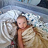 baby, blanket, face, infant, playpen, fabric, indoor, soft_toy, furniture, expression, cute, child, person, wrapped, cozy, home, comfort, skin, resting, looking