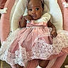 baby, infant, child, dress, pink, lace, headband, socks, footwear, baby_seat, fabric, lace_trim, cute, portrait, indoor, person, young_child, fashion, smile, comfortable