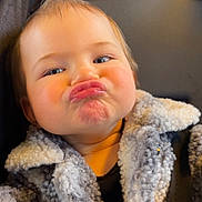 Alexane participe au concours pour gagner de l'argent avec cette photo : child, toddler, face, expression, pouting, jacket, fuzzy_clothing, blue_eyes, hair, cute, funny_face, portrait, indoor, seatbelt, car_seat, hand, skin, person, baby, cozy